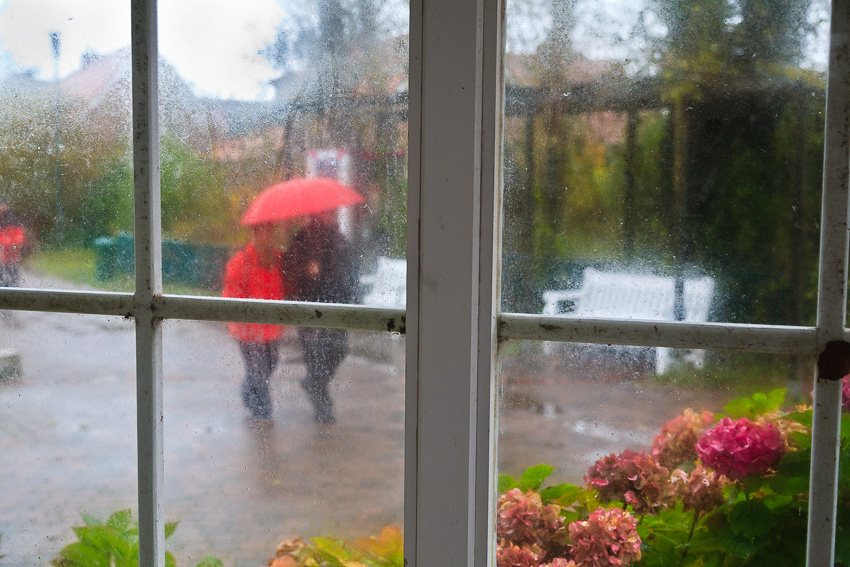 Zwei Personen im Regen durch eine Fensterscheibe fotografiert